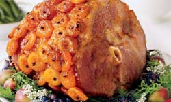 Glazed ham with apricots on dinner table
