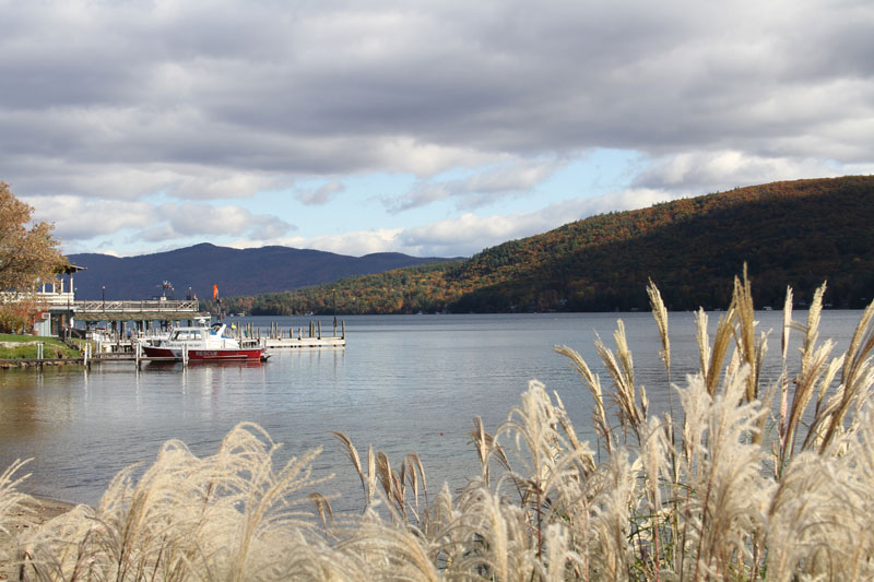 boat docked on lake george with fall foliage in the background