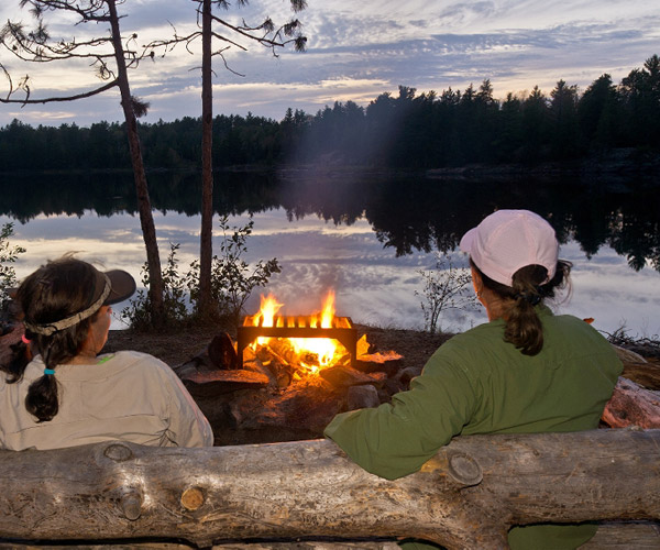 women sitting by a campfire