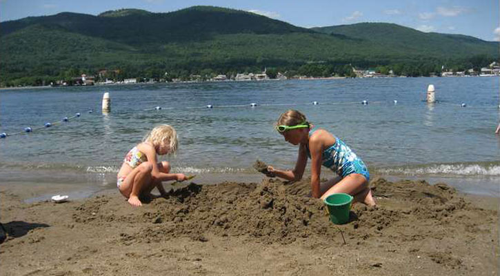 little girls building a sandcastle at the beach