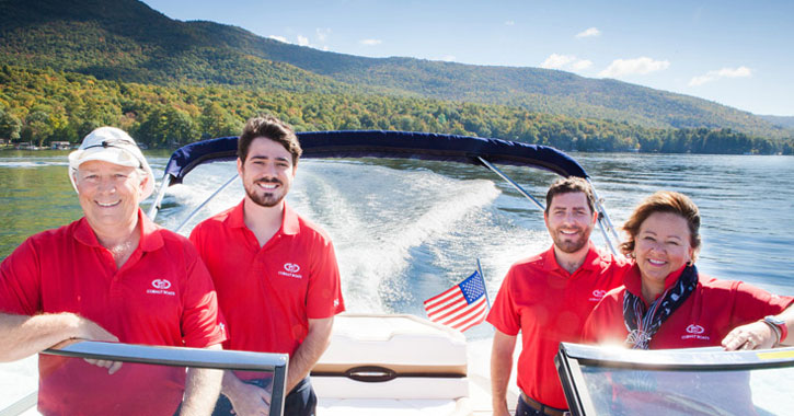 a family of four with red shirts on on a boat