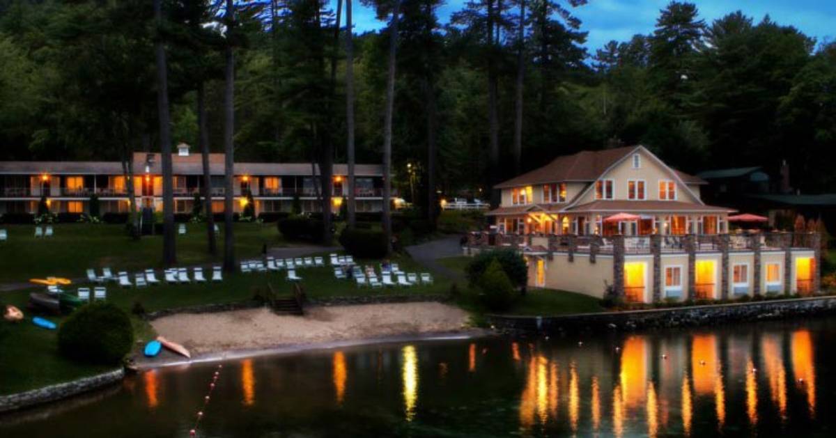 view of waterfront property with lights on at night