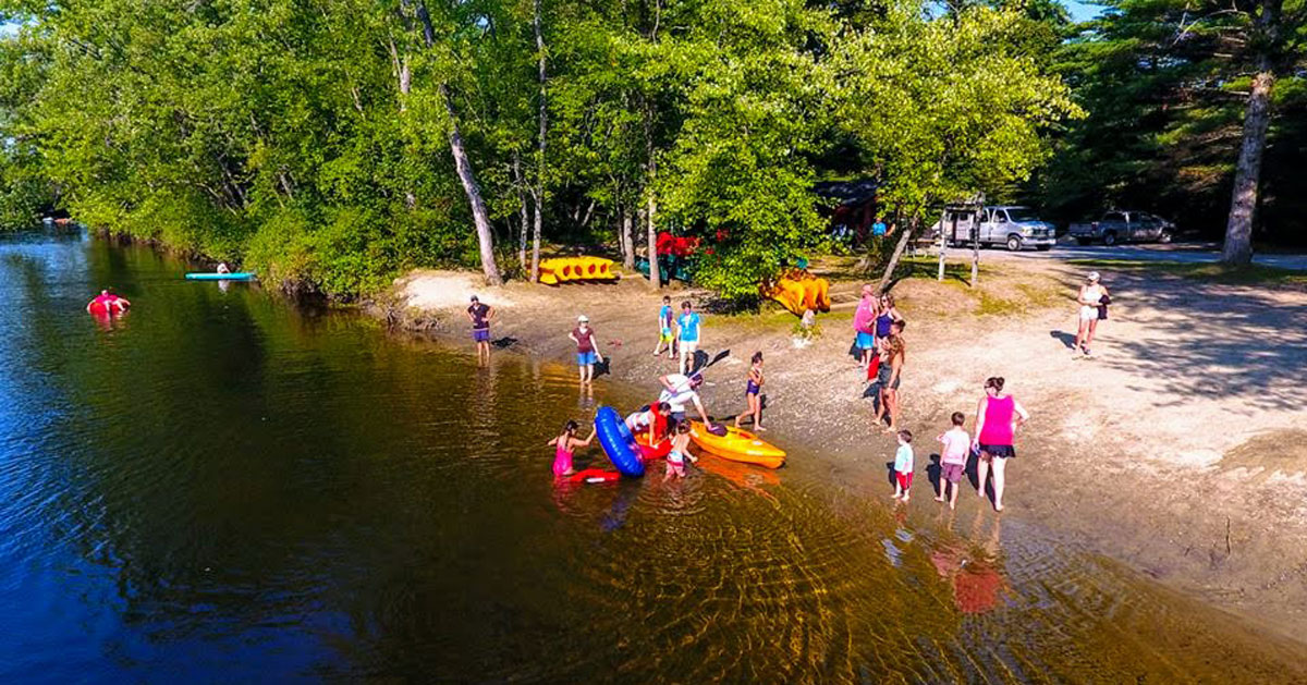 families in water and by lake beach