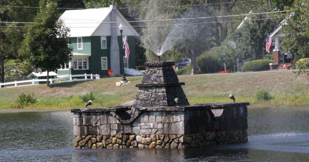 stone fountain spraying water in a lake