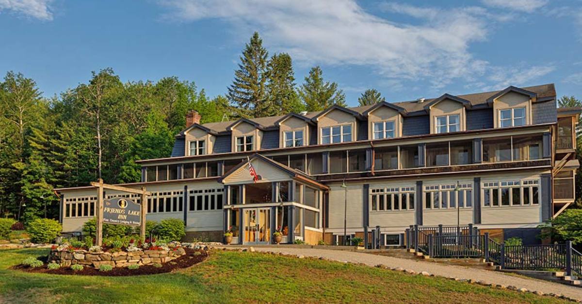 exterior of a hotel near trees with a front sign that reads friends lake inn