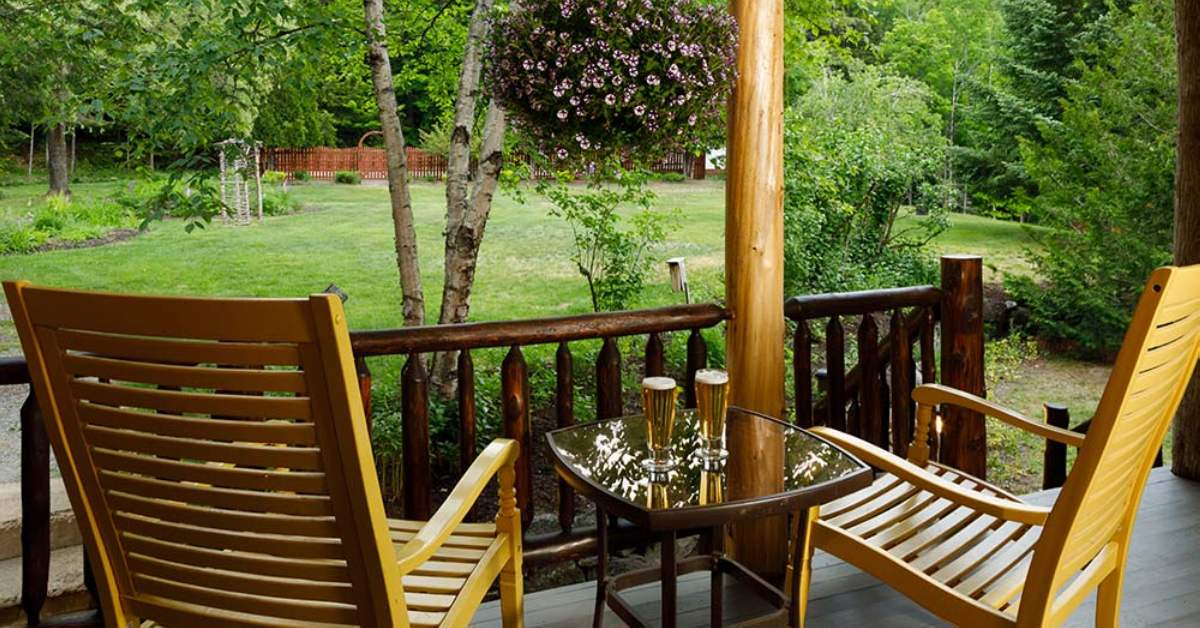 two chairs on a deck and two beers on a table