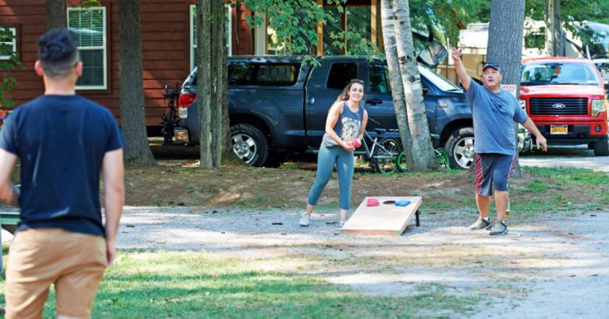 small group of people playing corn hole
