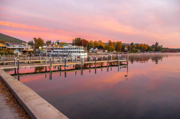 Pink sunrise over lake with fall foliage