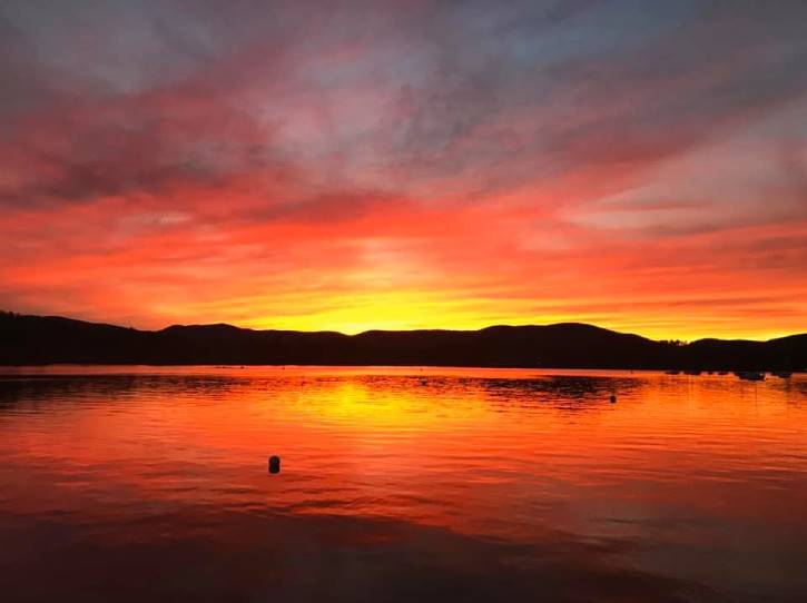 Yellow and orange sunset over lake with mountains