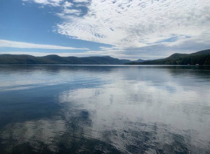 Blue sky with clouds reflecting on a lake