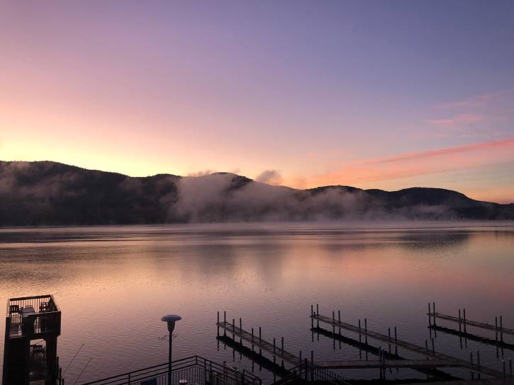 Pastel pink and blue sunrise over misty lake