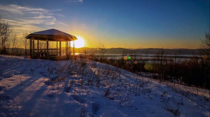 Gazebo pictured at sunset with snow and mountains