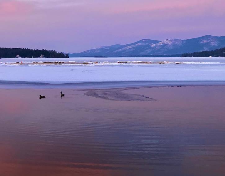 Purple sky reflecting off partially frozen lake