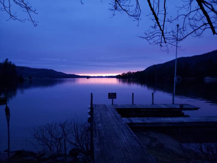 Dock on a lake with a blue and pink sunrise