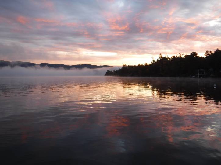 Mist over lake with pastel pink and yellow sunrise