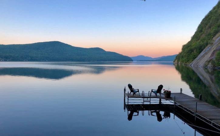 Sunrise over lake with dock & 2 Adirondack chairs