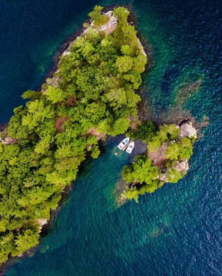 Aerial shot of a small island with two boats