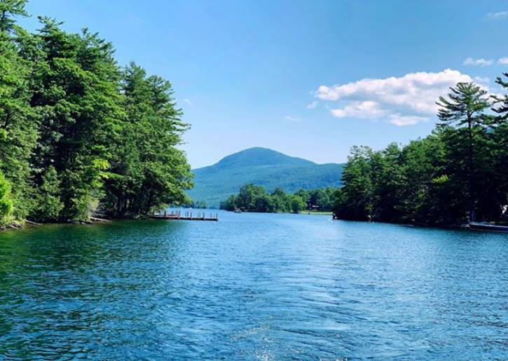 Sunny blue sky over lake with mountain view