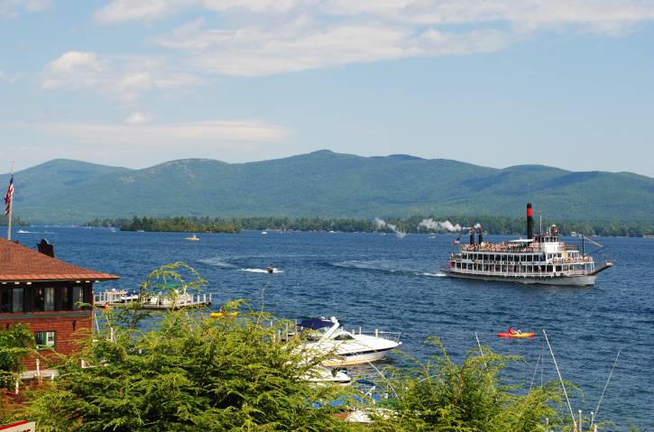 White steamboat on lake with mountain backdrop