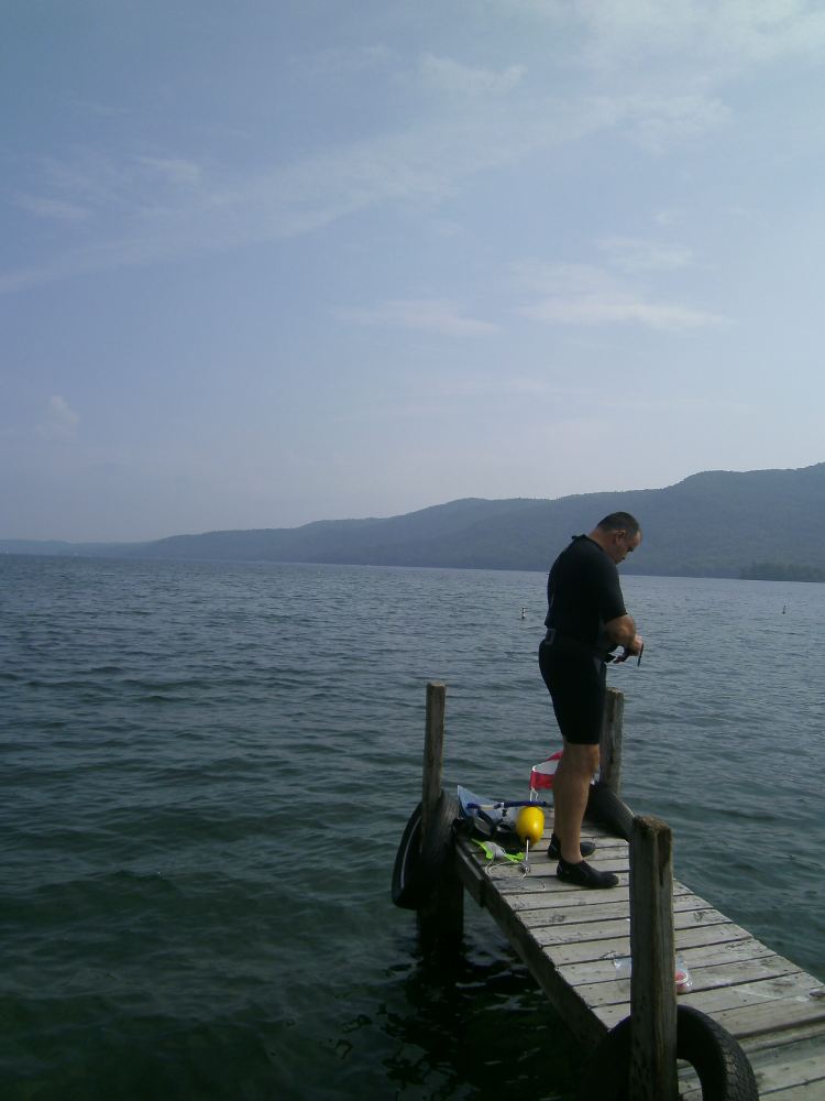 man standing on dock preparing for scuba diving