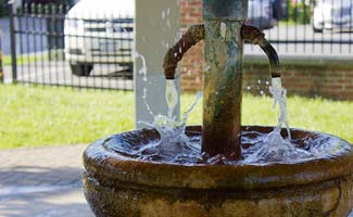 a small spring with water gushing out of two spouts