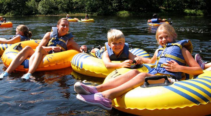 people on yellow tubes floating in the river