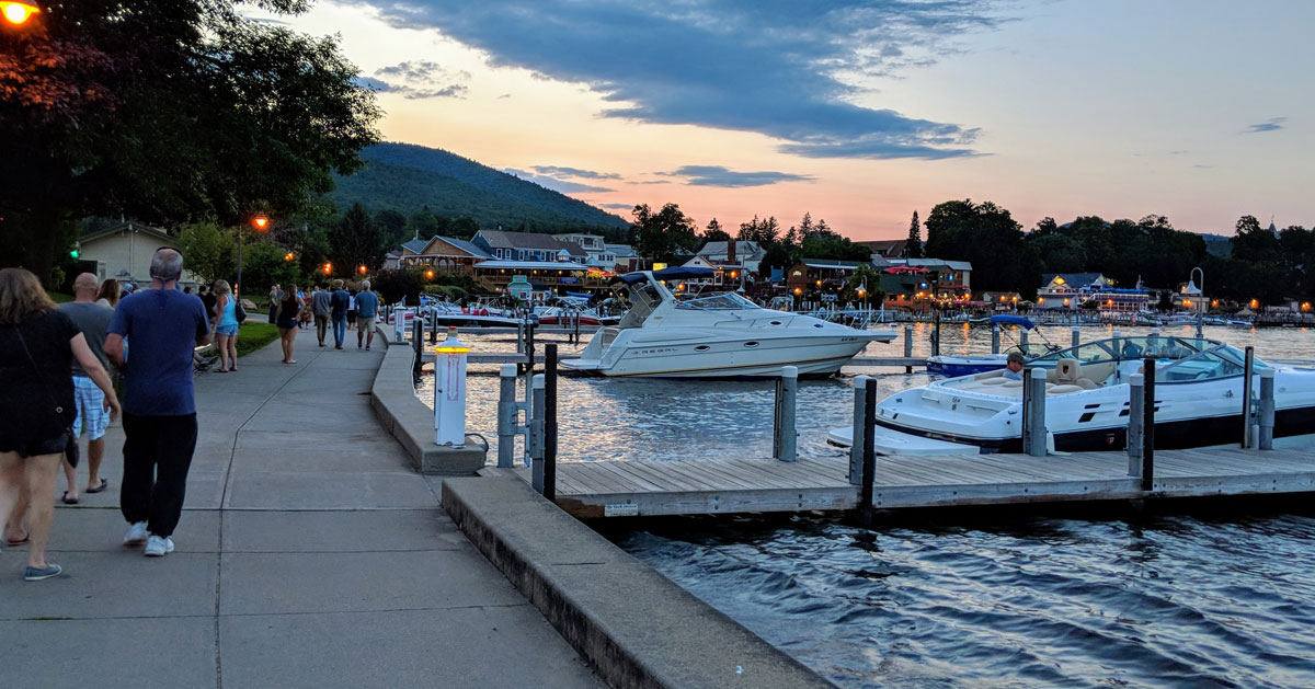 people walking by lake at dusk