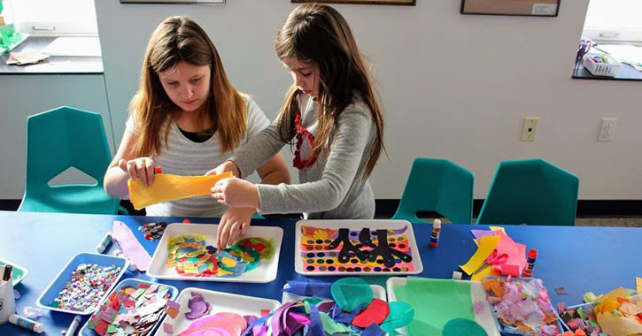 a woman doing crafts with a little girl