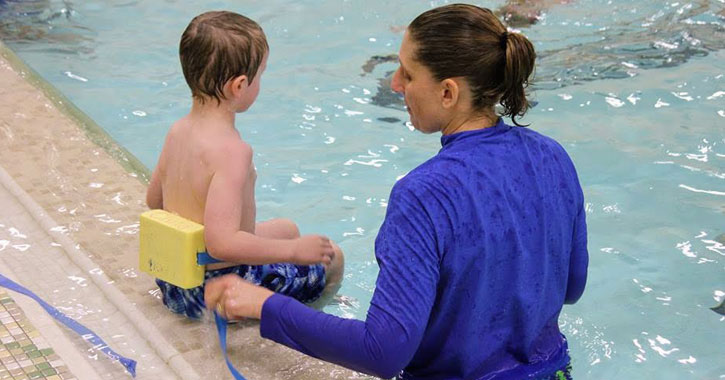 a woman and a little boy in a pool