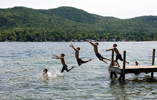 boy jumping in lake